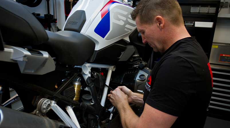 Motorradmechaniker Sven Kurtenbach bei der Diagnose und Fehlersuche am Motorrad