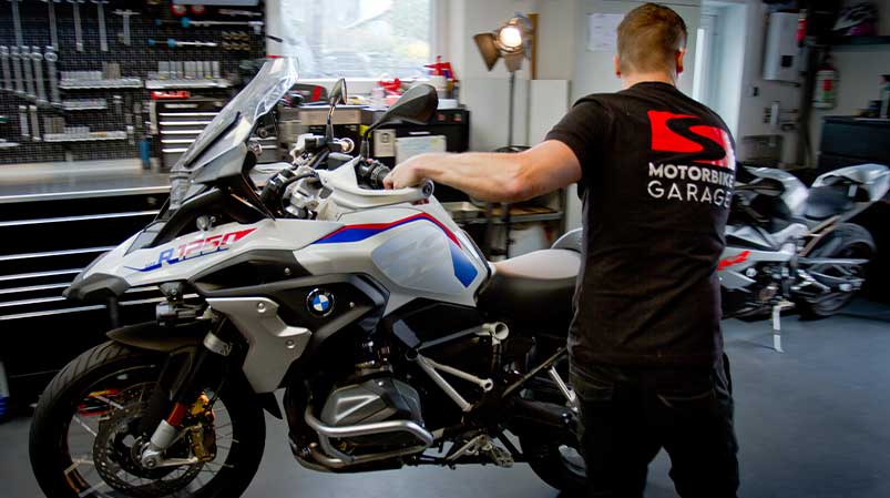 Motorradmechaniker Sven Kurtenbach bei der Arbeit am Motorrad inkl. HUK AU