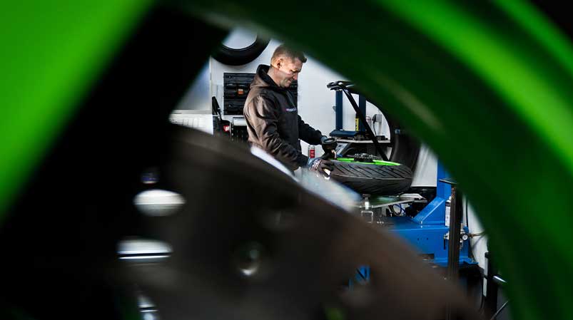 Motorradmechaniker Sven Kurtenbach bei der Arbeit am Motorradreifen