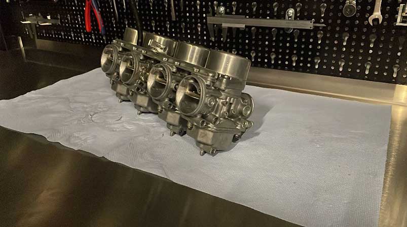 Abbildung eines Motorradsvergasers bei der Reinigung