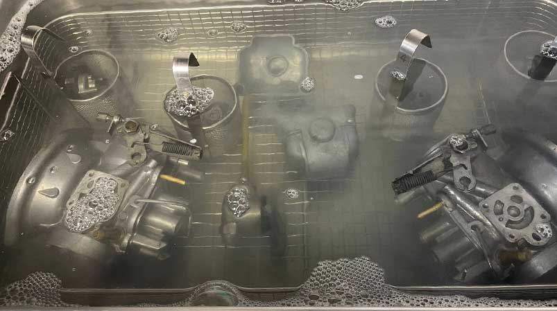 Motorradmechaniker bei der Reinigung eines Motorradvergasers